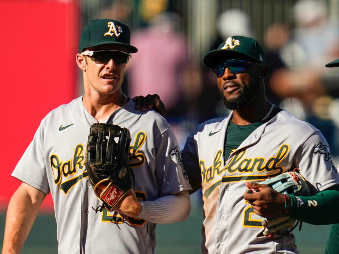 Oakland Athletics left fielder Mark Canha (20) and center fielder Starling Marte (2) and right fielder Chad Pinder (4) react after defeating the Kansas City Royals at Kauffman Stadium.